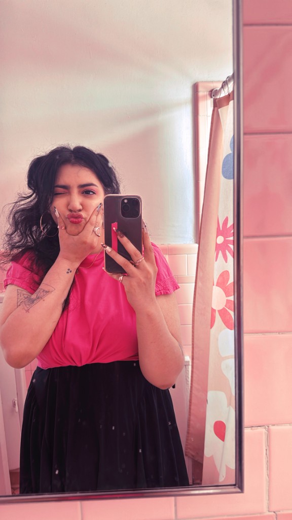 Shanyce taking a mirror photo in a pink shirt